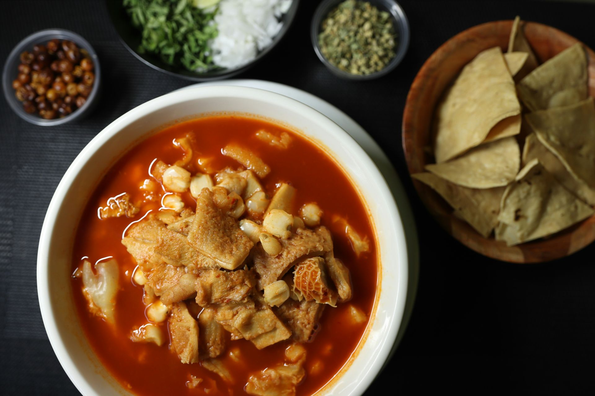 A bowl of soup with tortilla chips and salsa